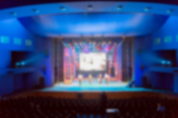 Defocused image. Artists, scenery, led screen and lighting equipment on the stage.