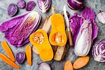 Seasonal winter autumn fall vegetables over gray stone table. Plant based vegan or vegetarian cooking concept. Clean eating food, alkaline diet