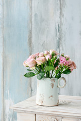 Bouquet of pink roses on blue wooden background