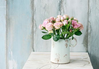 Bouquet of pink roses on blue wooden background