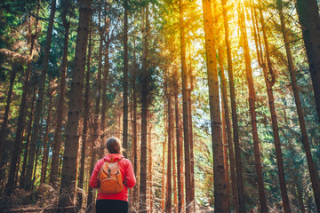 Adventure woman with vintage backpack in forest