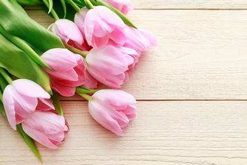 Obraz na płótnie Canvas Beautiful pink and white tulips on wooden background