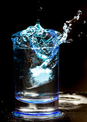 shot of whiskey with splash on black background