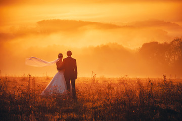 Bride and groom together in orange autumn morning