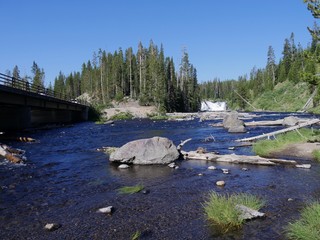 Wide shot of Lewis River with Lewis Falls and the bridge at Yellowstone National Park, Wyoming, USA