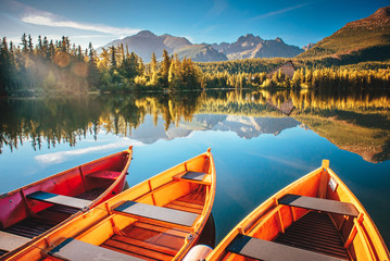 Morning lake Strbske pleso in Tatra mountains. Colorful boats on the water - obrazy, fototapety, plakaty