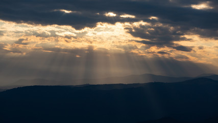 Beautiful sunset rays falling on top of a valley in Buila Vanturarita mountains, Romania
