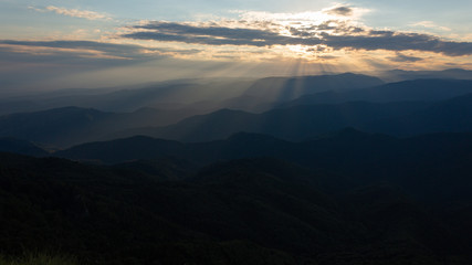Beautiful sunset rays falling on top of a valley in Buila Vanturarita mountains, Romania