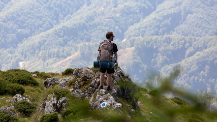 Fototapeta na wymiar Young man hiking through the beautiful mountains of Romania