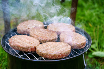Burgers are fried on the grill outdoors