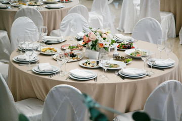 Served for banquet restaurant table with dishes, snack, cutlery, wine and water glasses, european food, selective focus