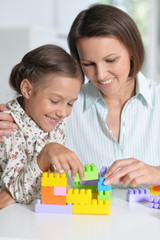 Curly little girl and her mother playing