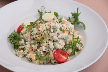 Traditional Russian Christmas Salad Olivier on a white plate