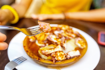 Happy woman eating delicious grilled octopus, spanish and mediterranean seafood cuisine concept