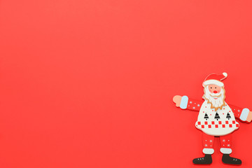 Toy Santa Claus shows to red background.   Christmas, New Year concept, gifts, travel and shopping.