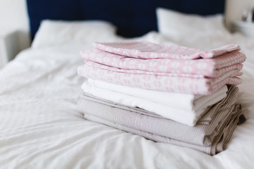 a stack of clean and ironed linen is on the bed