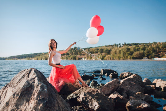 Pretty girl with many colored balloons in hand