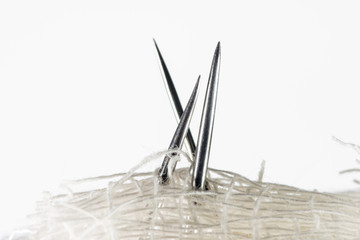 Needle tip close up and white fabric, visible filament fibers