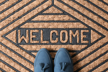 Blue female shoes on brown welcome doormat, top view