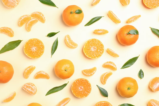 Composition with tangerines and leaves on color background, flat lay