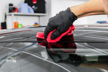A man cleaning car with microfiber cloth. Car detailing concept. Car detailing. Cleaning with sponge. Car Worker cleaning with Microfiber. Solution to clean. Vehicle washing station