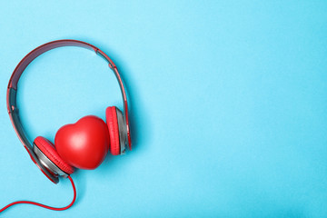 Flat lay composition with heart, headphones and space for text on color background