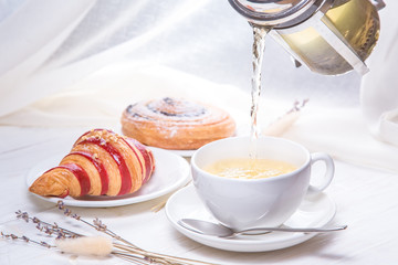 green tea with croissants on white wooden background