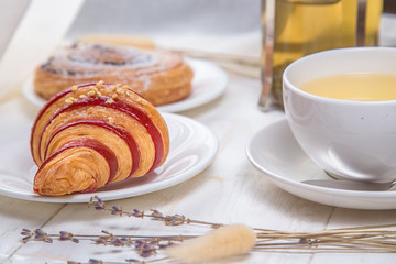 green tea with croissants on white wooden background