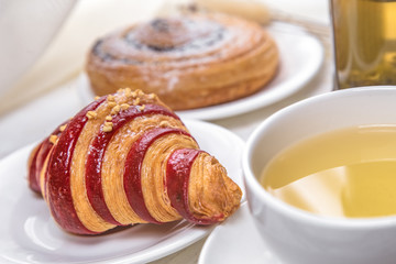 green tea with croissants on white wooden background