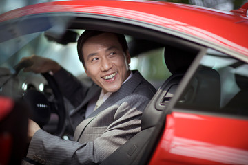 Mid-adult businessman sitting in a car.