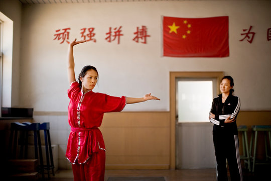 Portrait of a teenage girl performing martial arts in a gym.