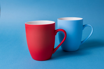 Red and blue mugs on a blue background.