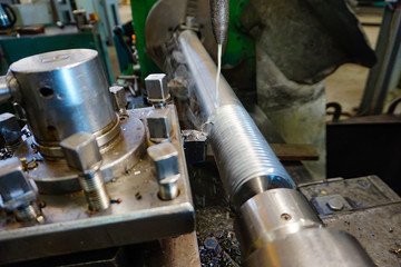 Making threads on a lathe with a cutter. Coolant in metalworking.