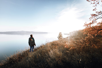 A man on the edge of a cliff in the woods