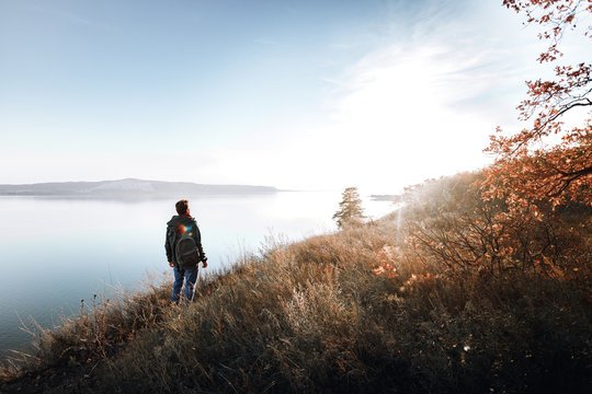 A man on the edge of a cliff in the woods