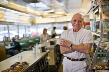 Man standing in old fashioned diner behind counter