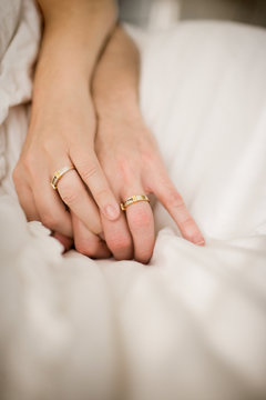 Matching wedding bands on the hands of a couple.