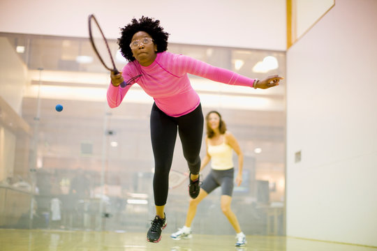 Two women playing racquetball together.