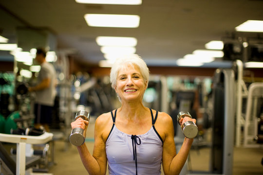 Smiling mature woman working out at the gym.