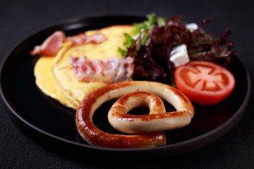 continental breakfast, protein meals, nourishing morning food. appetizing omelette with bacon, sausages and vegetable salad