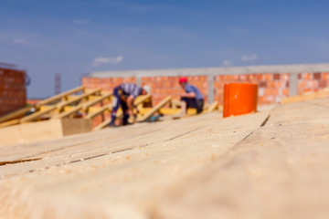 Construction crew of carpenters is working on the new roof