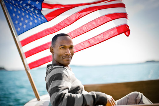 Man on boat sitting under the American flag