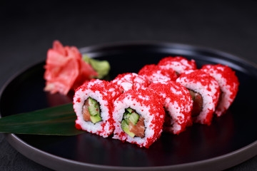 sushi, japanese food, deluxe restaurant menu, delicious traditional seafood. maki sushi roll with salmon and cucumber, covered with calf caviar