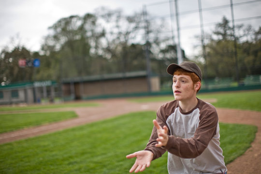 Boy catching ball on baseball pitch