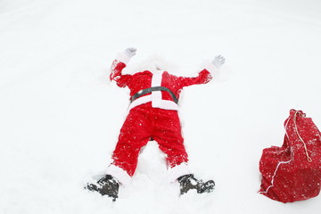 Père Noël est couché dans la neige.