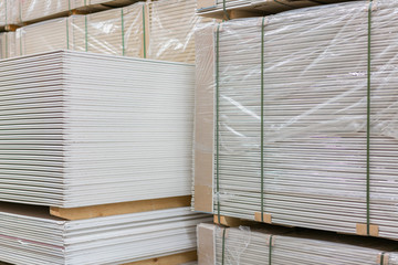 Gypsum plasterboard in the pack. The stack of gypsum board preparing for construction. Pallet with plasterboard in the building store. Construction Materials. Drywall warehouse.