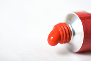 Red acrylic paint squeezed out of the tube. Selective focus and shallow depth of field.
