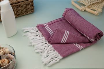 Handwoven hammam Turkish cotton towel on light blue frosted glass background