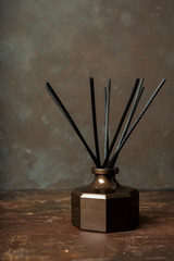 Simple aroma reed diffuser, home fragrance bottle with rattan sticks on nature background with copy...
