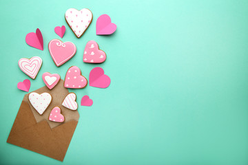 Homemade valentine cookies with envelope on mint background
